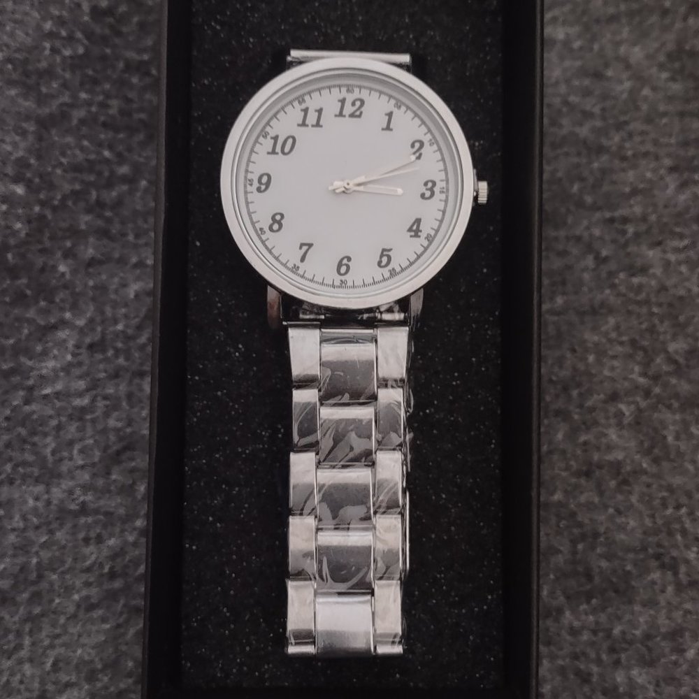 QUARTZ WATCH WITH WHITE FACE AND BOLD NUMBERS.